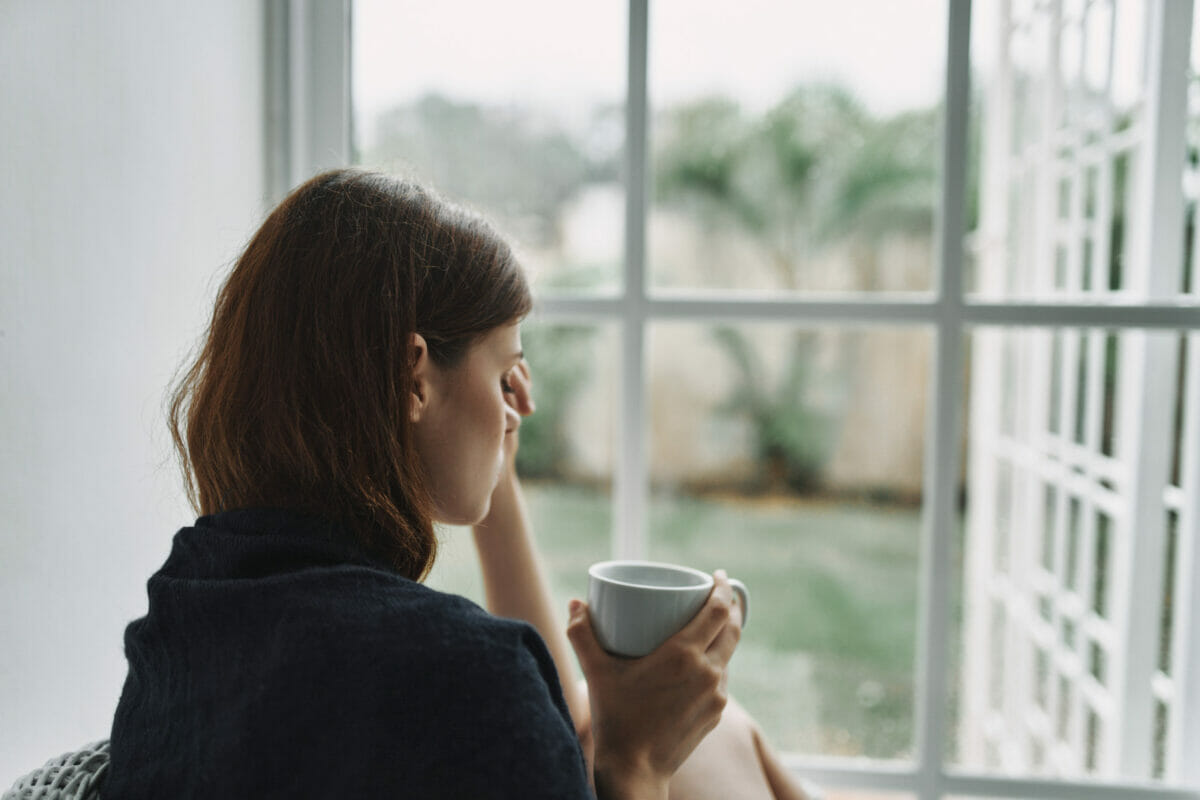 Why are mornings the hardest after a breakup? Upset woman with a cup of coffee in the morning.